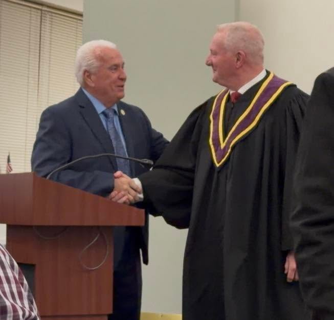 Community leaders shaking hands at a formal ceremony